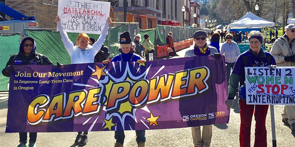 Женщины держат в руках пурпурный баннер «Care Power» в марте в Портленде